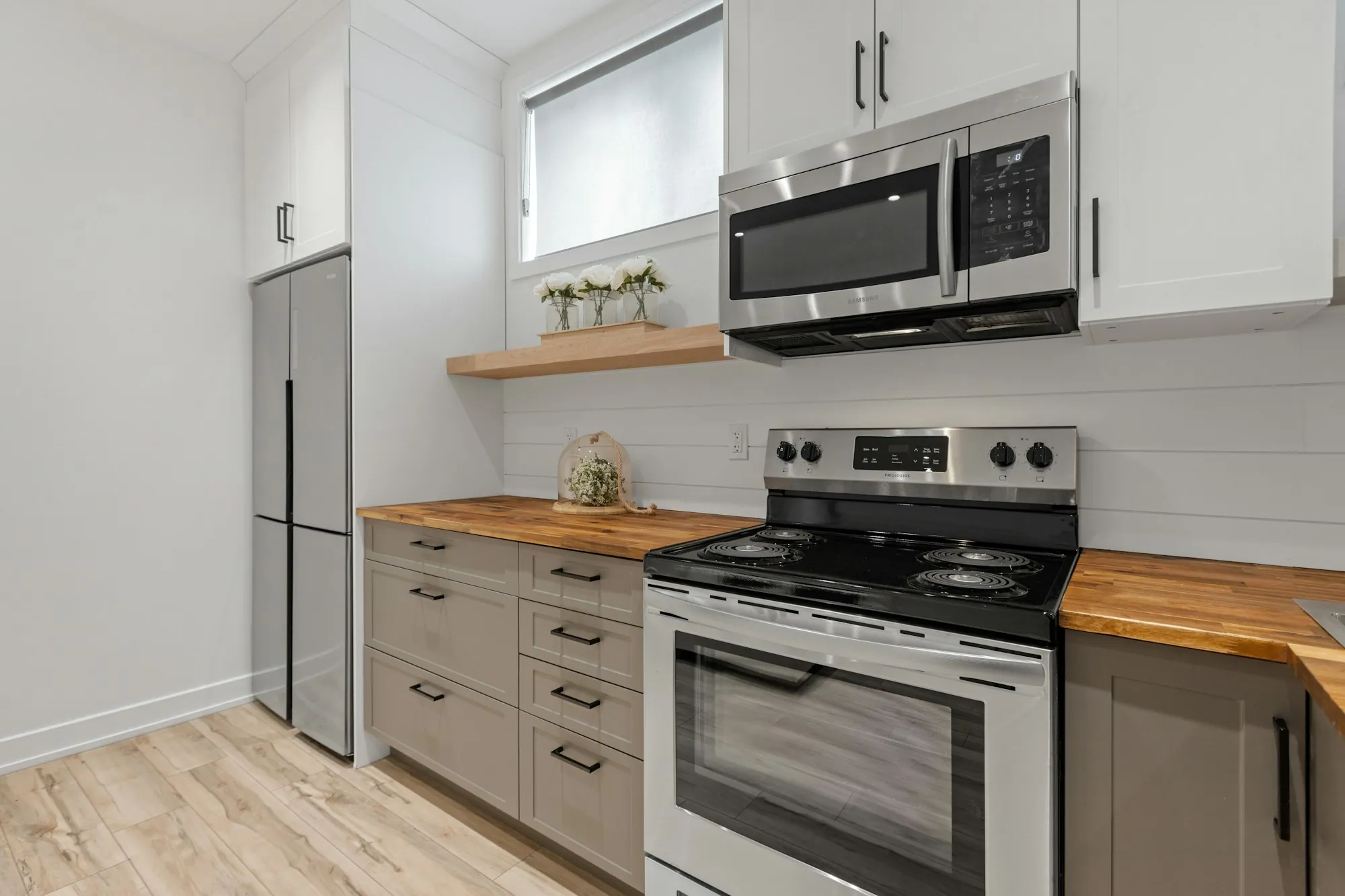 Compact kitchen with butcher-block counters and stainless appliances